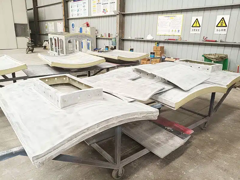 Factory production of train ride components, including train carriage parts and locomotive body, ready for assembly.