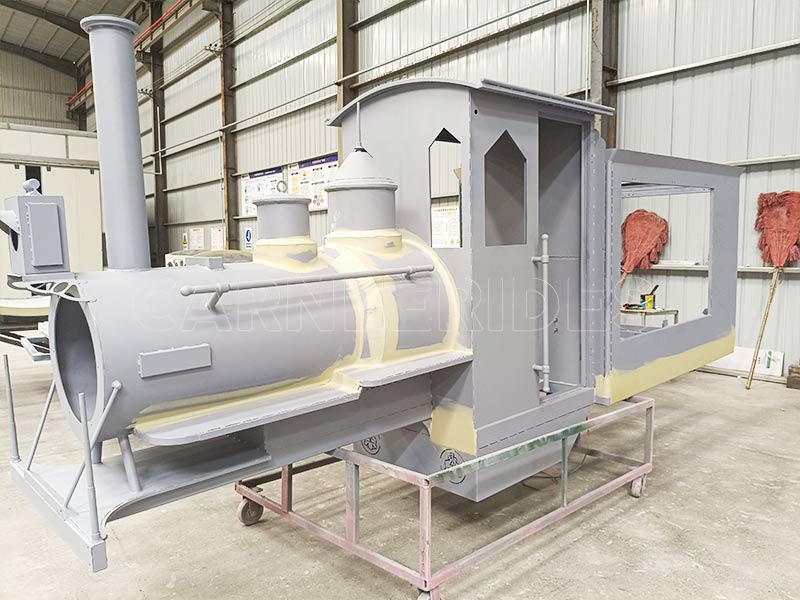Work-in-progress locomotive frame, part of a amusement park train, in the factory assembly line.