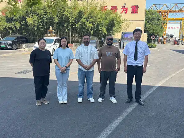 Customers visiting Carnee Rides amusement equipment factory and taking a group photo at the entrance