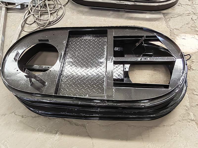 Multiple amusement bumper cars displayed in the workshop, showing various fiberglass body styles and seating designs.