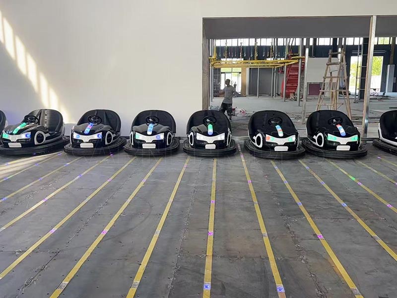 Black ground grid bumper cars lined up on a steel floor-grid system, showcasing high-quality electric bumper cars for amusement parks and FECs.