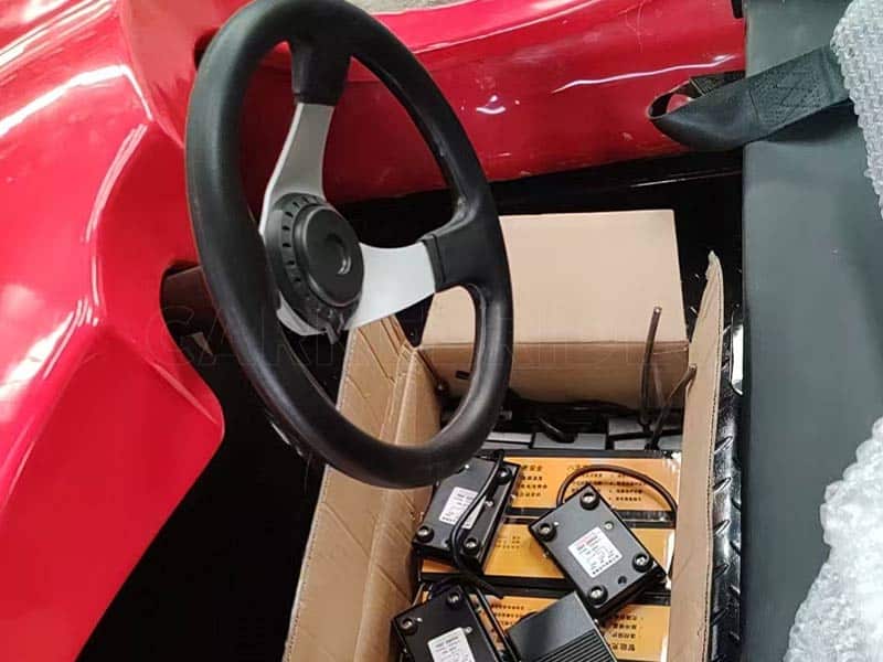 Bumper car assembly workshop showing steering wheel installation and fiberglass body preparation for ground grid bumper cars.
