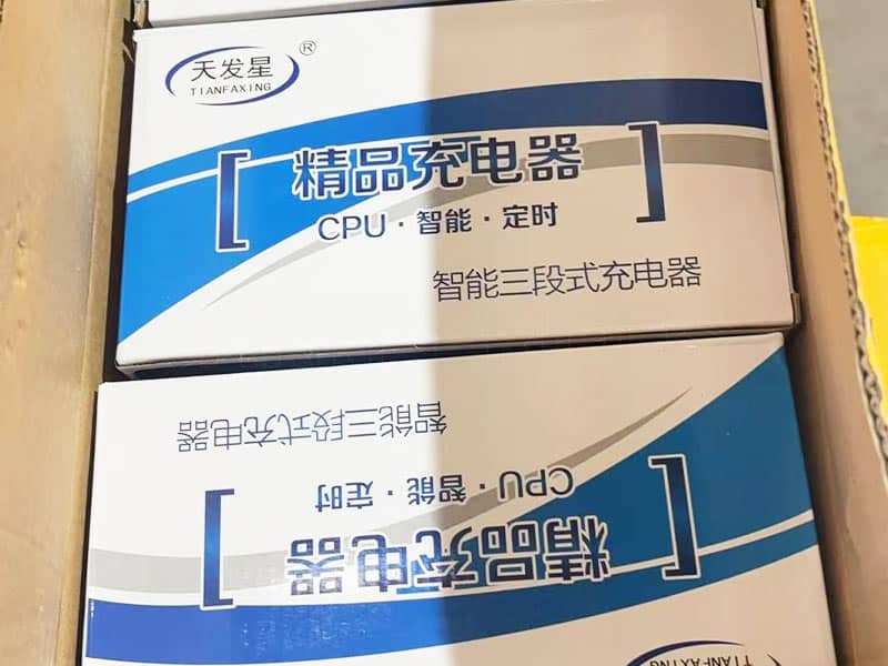 Boxed bumper car battery chargers neatly packaged for shipment, featuring intelligent CPU-controlled charging technology.