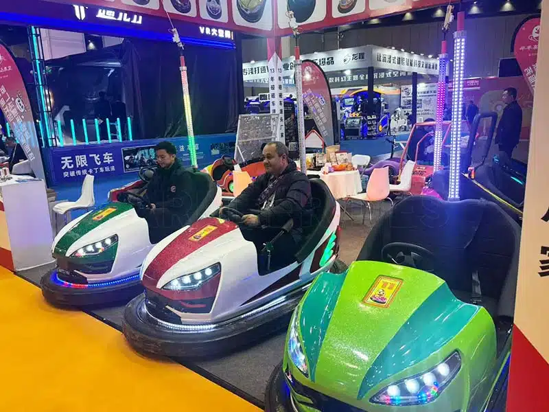 Electric bumper cars showcased at an amusement ride exhibition, allowing visitors to test the latest dodgem car models.