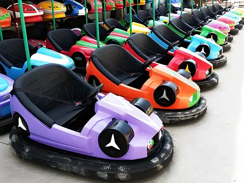 A group of ceiling bumper cars in the assembly area, each car equipped with safety features such as seat belts, rubber bumpers, and LED lights. Ready for shipment to theme parks for thrilling bumper car experiences.