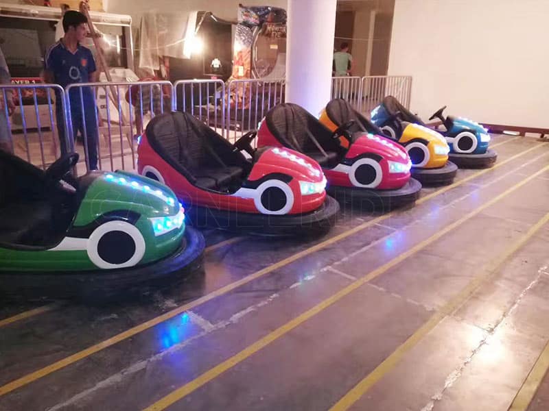 Indoor LED floor-grid bumper cars with bright headlights, showing electric ground net bumper cars for sale in various colors.