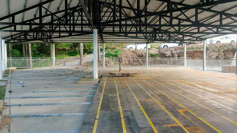 Progress of modular ground grid floor installation for bumper cars, with steel conductive panels and copper strips aligned in rows.