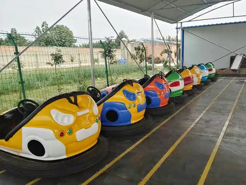 Outdoor floor-grid bumper cars arranged along the conductive tracks, featuring durable fiberglass electric dodgem cars for amusement parks.