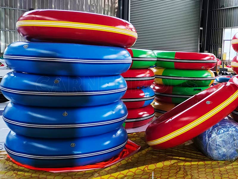 Stacked colorful 0.9mm PVC anti-collision inflatable rings ready for assembly on battery-operated bumper cars.