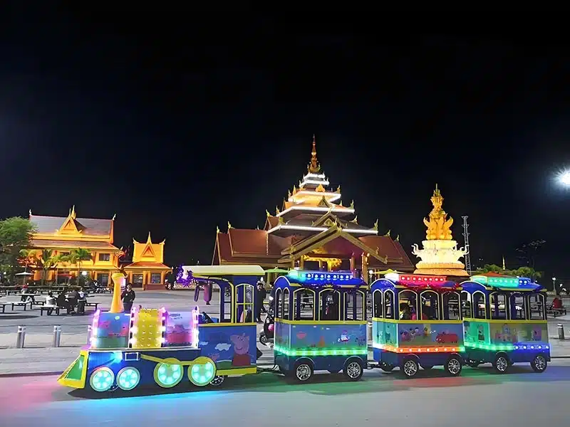 Brightly lit electric trackless sightseeing train with colorful LED lights. Ideal for family-friendly attractions, theme parks, and recreational areas. Offers a fun and environmentally-friendly ride experience.