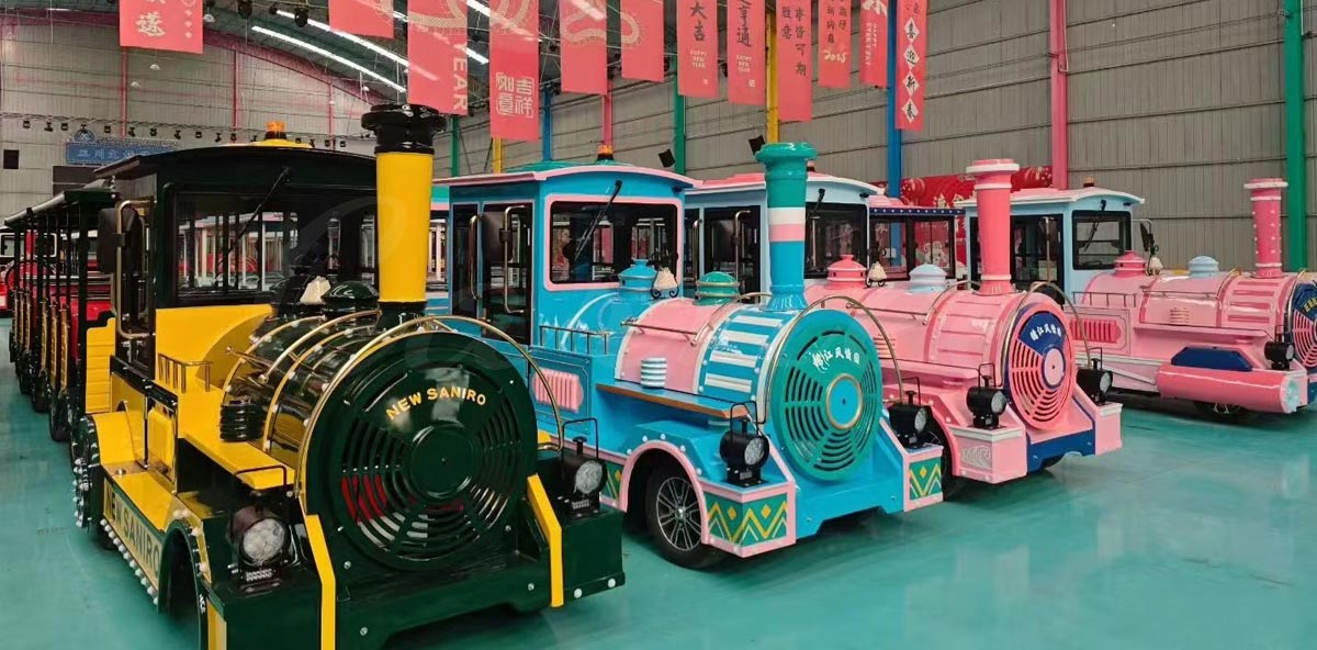 A fleet of custom-themed trackless mall trains painted in bright pastel colors like pink and light blue, ideal for family entertainment centers.
