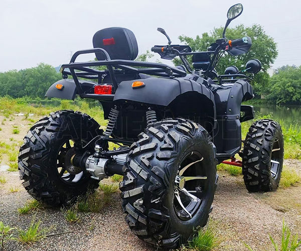 Sebuah ATV komersial berwarna hitam tugas berat yang diparkir di dekat sungai, menyoroti tekanan ban yang rendah dan pola tapak yang dalam yang diperlukan untuk memaksimalkan traksi di jalur off-road yang lembut.