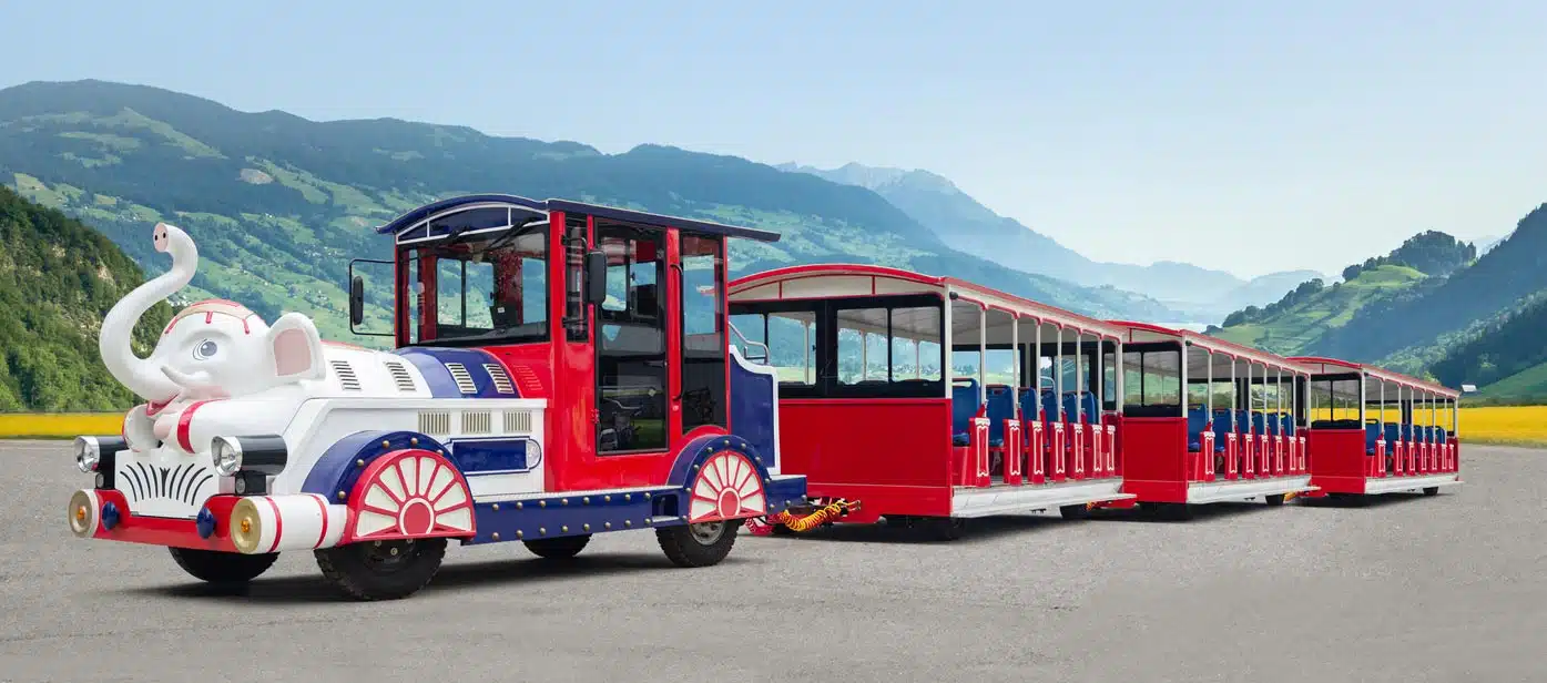 Train sur rails à piles pour éléphants, manège pour enfants dans un parc d'attractions, train touristique électrique dans une aire de jeux en plein air.