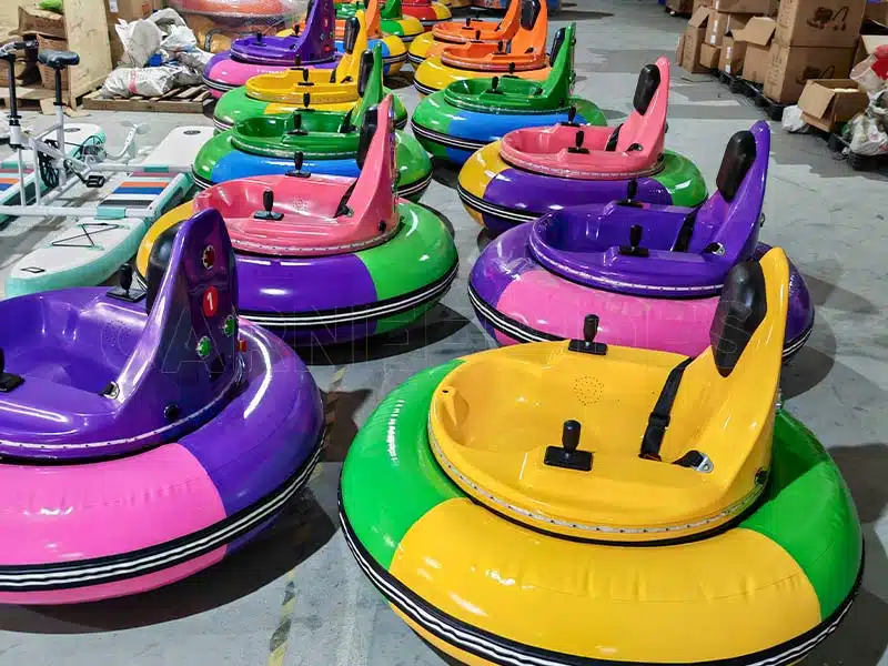 high-gloss pink inflatable bumper cars and other colors bumper cars on the Carnee Rides factory assembly line, showing metallic blue base frame.