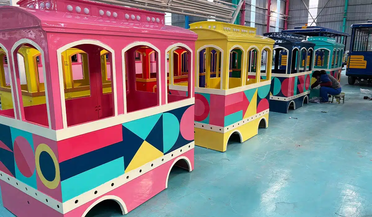 Colorful trackless train carriages in factory showing passenger cabins for amusement park train cost comparison