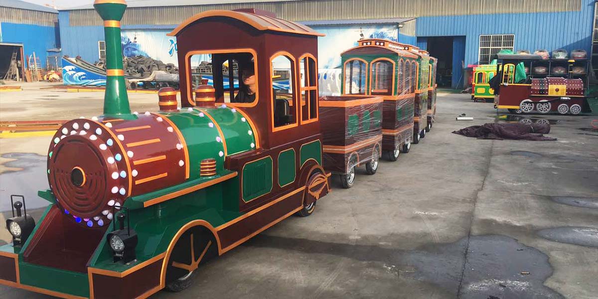Vintage style trackless tourist train in factory with wooden finish carriages for park and resort operation