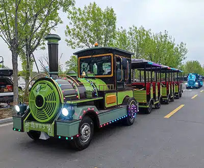 28-seat green trackless tourist train with open passenger carriages for parks and scenic attractions