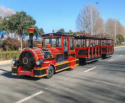 42-seat red trackless sightseeing train with multiple open passenger carriages operating on a park road