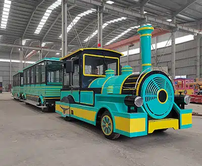 58-seat turquoise commercial trackless train with large passenger carriages displayed inside the factory