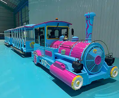 72-seat blue and pink large-capacity trackless train with multiple passenger carriages inside the manufacturing facility