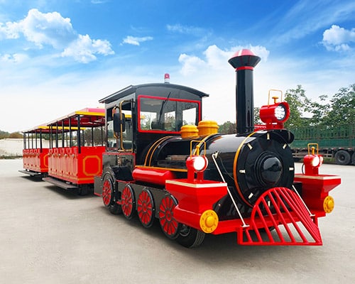 Red vintage-style trackless train ride with passenger carriages for amusement parks and theme parks