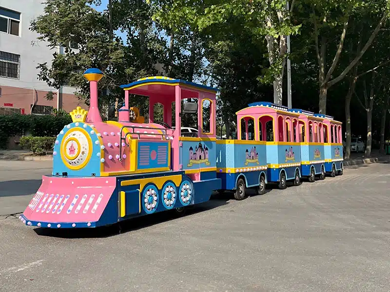 Colorful pink electric trackless train ride with multiple passenger carriages for amusement parks and family attractions