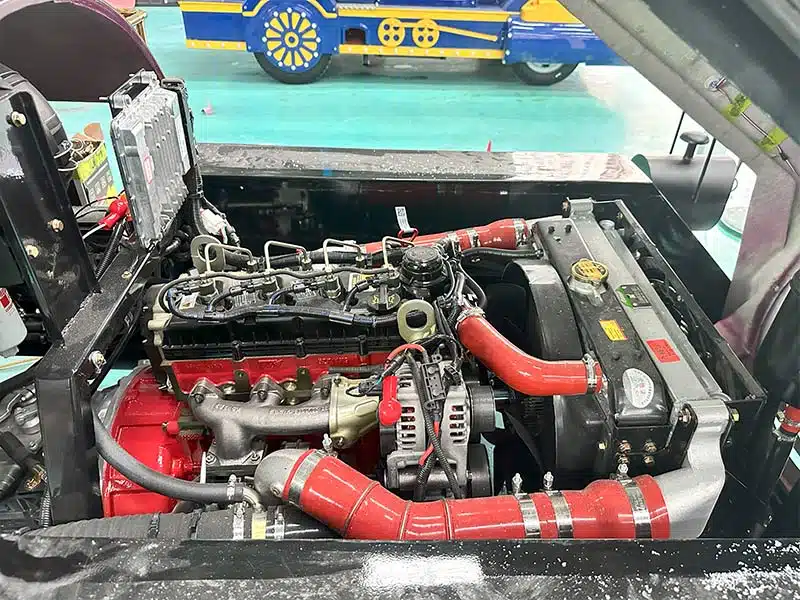 Diesel engine and cooling system inside a commercial trackless train during factory inspection