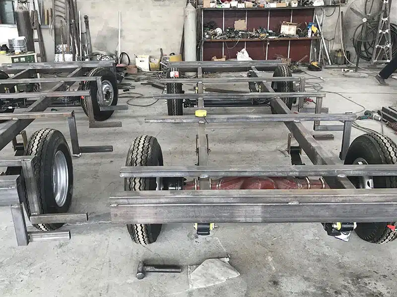Steel chassis frames for trackless train passenger carriages during factory fabrication