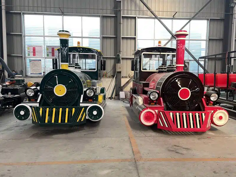 Two commercial trackless train locomotives photographed from the front during factory inspection and preparation