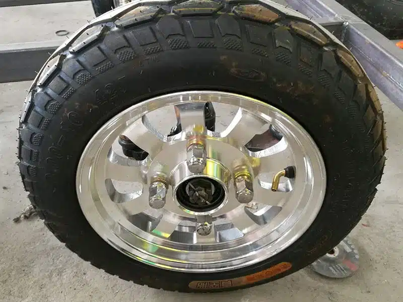 Trackless train wheel and tire assembly used on commercial passenger train carriages